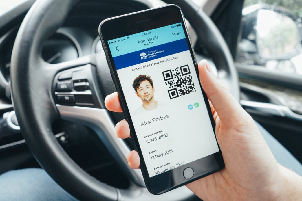 Man holding phone with digital drivers licence on screen