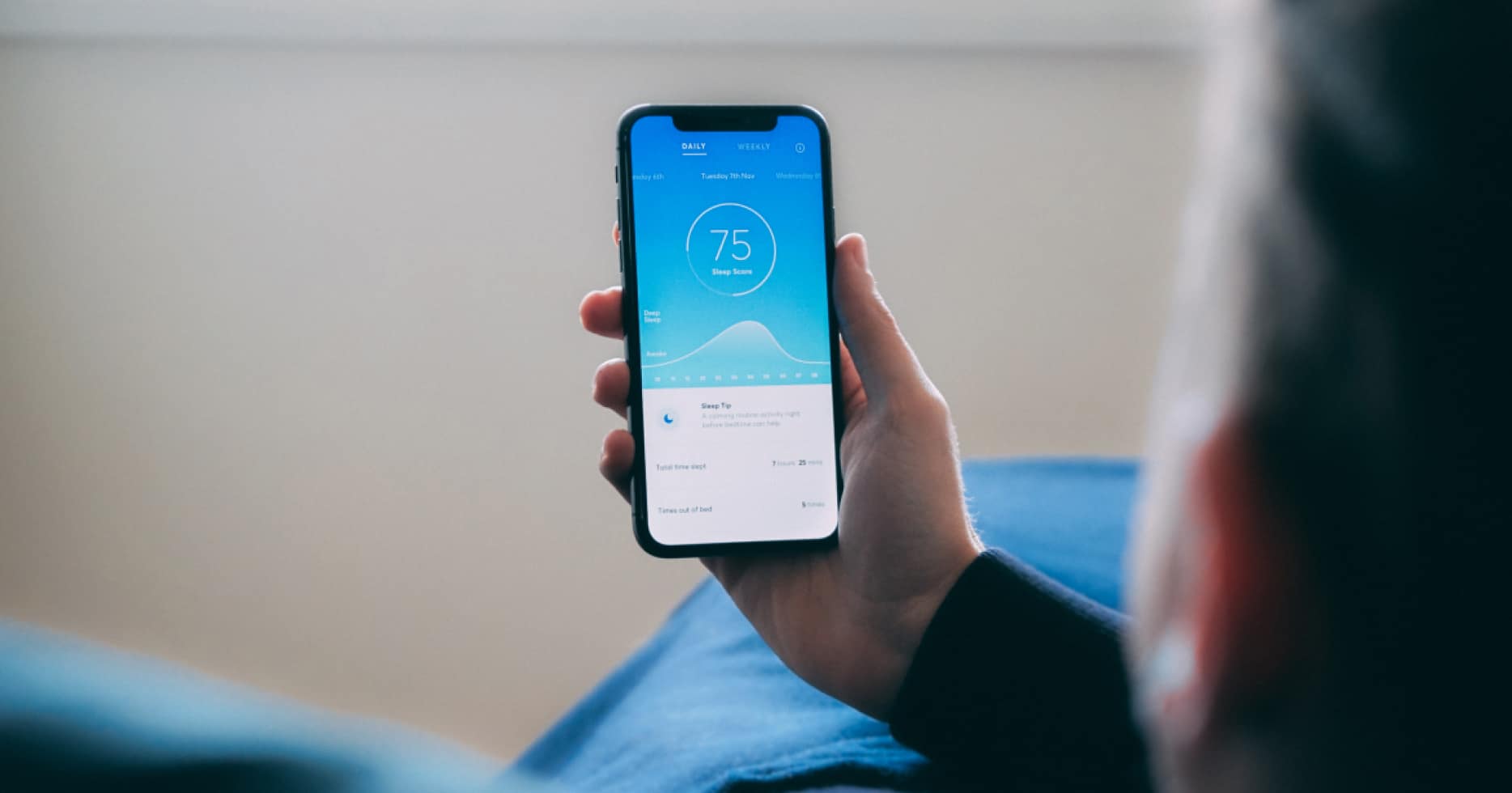Man holding phone with sleep tracker showing